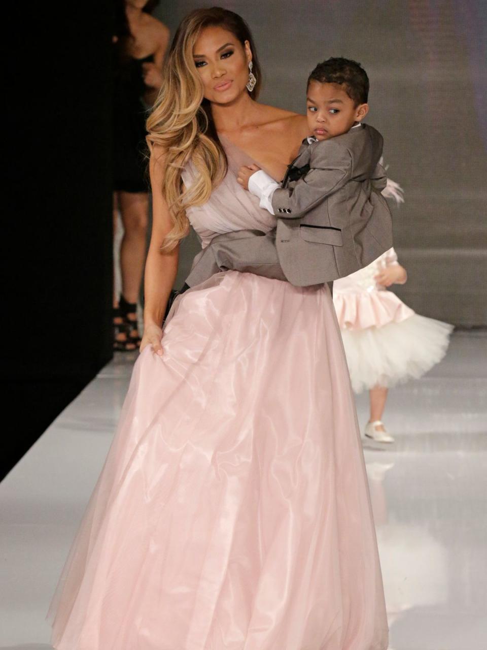 Model Daphne Joy carrying her son, Sire Jackson fathered by former rapper 50cent in the Isabella Couture runway show