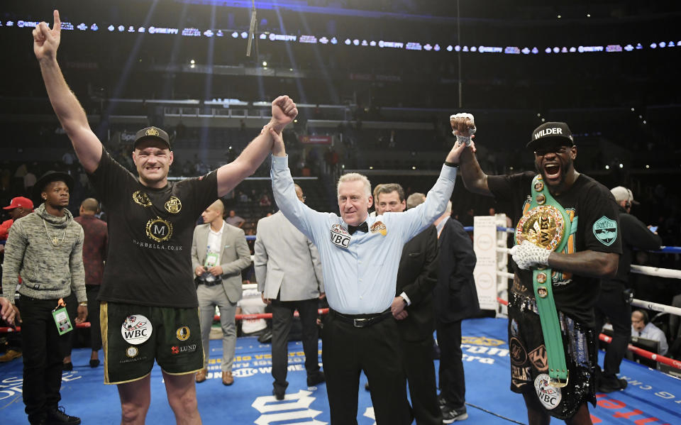 Tyson Fury, left, of England, poses with Deontay Wilder, right, along with referee Jack Reiss after their WBC heavyweight championship boxing match ended in a draw, Saturday, Dec. 1, 2018, in Los Angeles. (AP Photo/Mark J. Terrill)