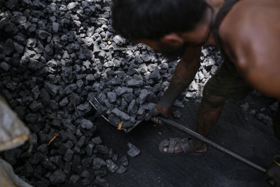 A worker loads coal into a sack at a coal wholesale market in Mumbai, India, on Thursday, May 5, 2022. Production of coal, the fossil fuel that accounts for more than 70% of India's electricity generation, has failed to keep pace with unprecedented energy demand from the heat wave and the countrys post-pandemic industrial revival. Photographer: Dhiraj Singh/Bloomberg