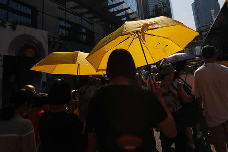 Demonstrators hold yellow umbrellas, the symbol of the Occupy Central movement, in protest of the jailing of student leaders Joshua Wong, Nathan Law and Alex Chow who were imprisoned for their participation of the 2014 pro-democracy Umbrella Movement, in Hong Kong China August 20, 2017. REUTERS/Tyrone Siu