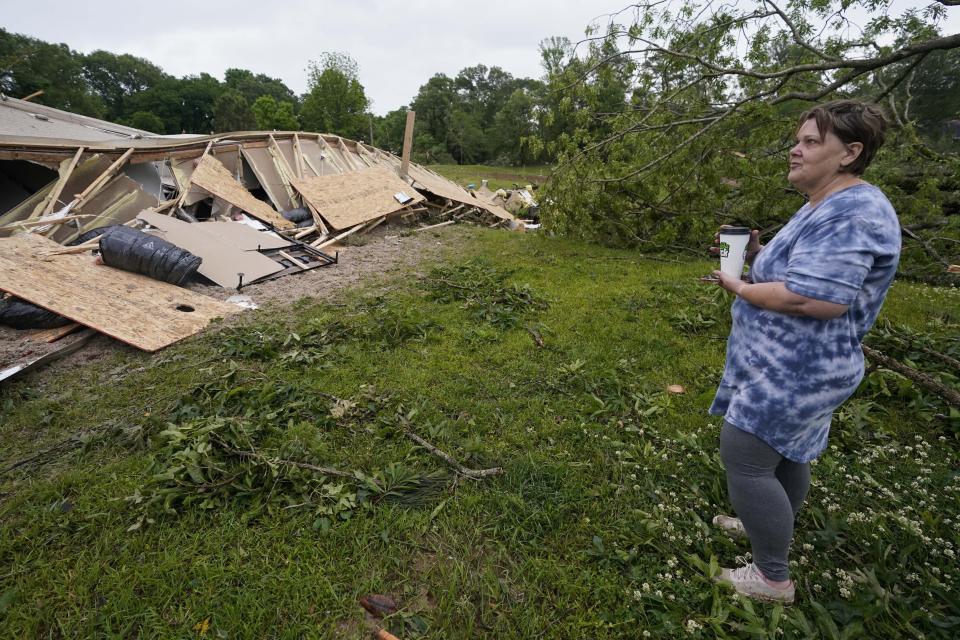 Vickie Savell looks at the remains of her new mobile home early Monday, May 3, 2021, in Yazoo County, Miss. Multiple tornadoes were reported across Mississippi on Sunday, causing some damage but no immediate word of injuries. (AP Photo/Rogelio V. Solis)