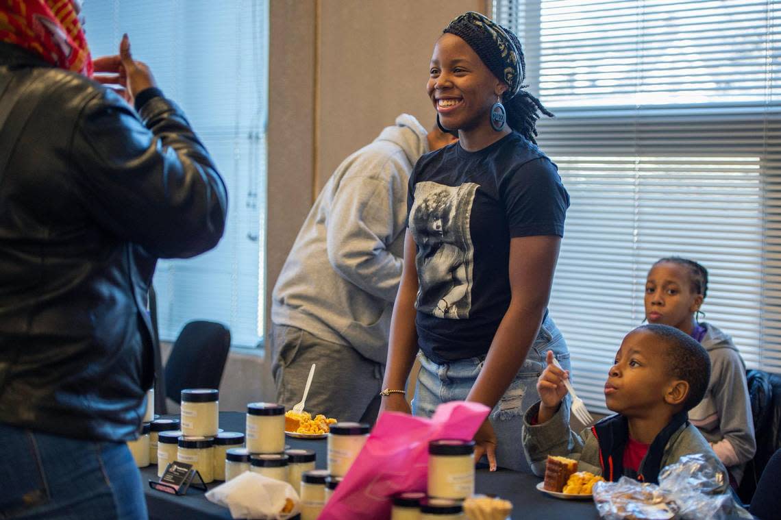 Zoé Grey, 13, owner of Zoe’s Pomades and Potions, helps a customer choose a homemade lotion during the Village event.