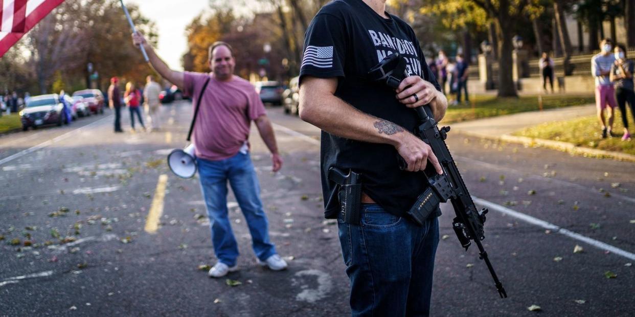 a supporter of us president donald trump keeps a hand on his gun during a 