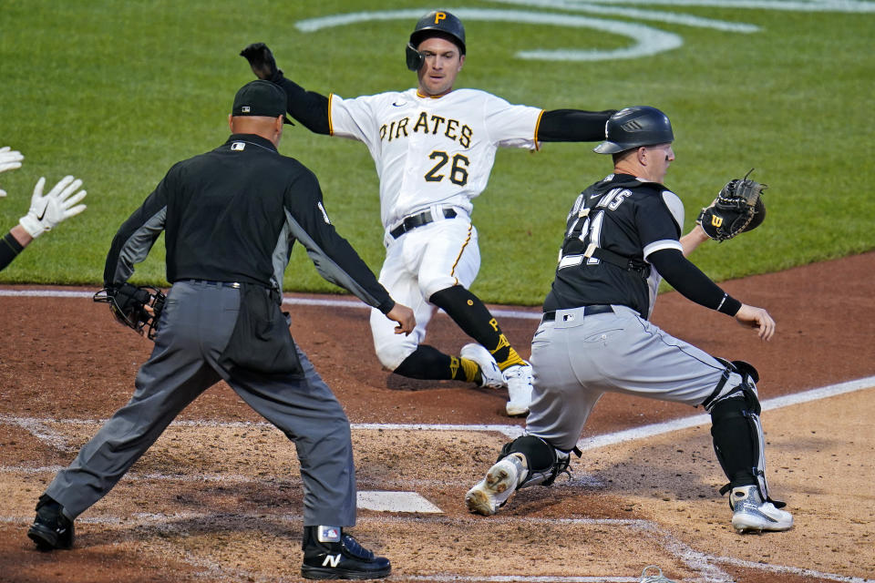 Pittsburgh Pirates' Adam Frazier (26) begins his slide and scores ahead of the throw to Chicago White Sox catcher Zack Collins, right, with umpire Vic Carapazza, left, watching the play during the sixth inning of a baseball game in Pittsburgh, Tuesday, June 22, 2021. Frazier scored on a single by Bryan Reynolds off White Sox starting pitcher Lucas Giolito. (AP Photo/Gene J. Puskar)