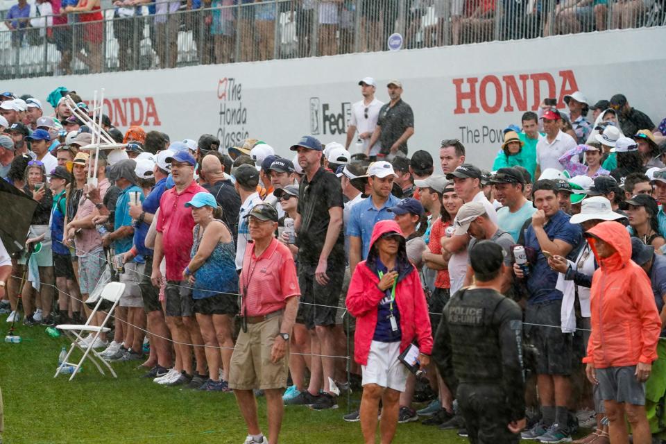 Fans brave the rain to watch the action on the 18th hole during the final round of The Honda Classic last February.