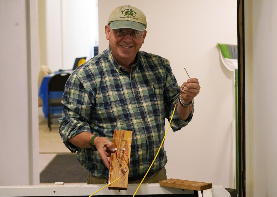 Co owner of Building Resilient Solutions, Kerry Shackelford displays pine boards that they use to test flood resistance at his lab Tuesday, Oct. 4, 2022, in Suffolk , Va. Whenever historic homes get flooded, building contractors often feel compelled by government regulations to rip out the water-logged wood flooring, tear down the old plaster walls and install new, flood-resistant materials. But Virginia restorers Paige Pollard and Kerry Shackelford say they can prove that historic building materials can often withstand repeated flooding. (AP Photo/Steve Helber)