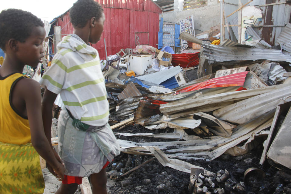 People look at destroyed shops in Mogadishu's Lido beach, Somalia, Saturday, April, 23, 2022, after a bomb blast by Somalia’s Islamic extremist rebels hit a popular seaside restaurant killing at least six people. Ambulance service officials say the explosion occurred Friday evening when many patrons gathered for an Iftar meal to break the Ramadan fast. (AP Photo/Farah Abdi Warsameh)