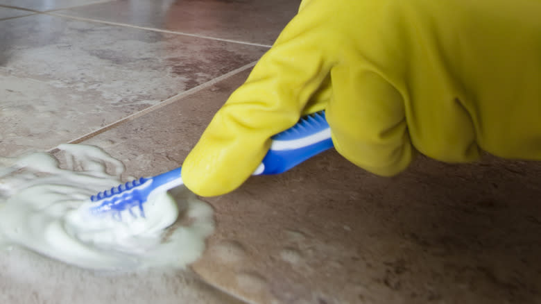 Hand scrubbing tile with toothbrush