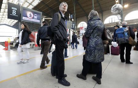 Travellers wait with their luggage at the Gare du Nord train station after a power outage that has suspended main line services, including the Eurostar, RER commuter trains and suburban train services at the station in Paris, France, December 7, 2016. REUTERS/Yves Herman