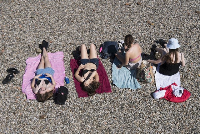 People sunbathe on the river bank in central London