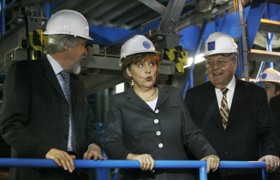 FILE - In this Tuesday, April 29, 2008 file photo made by Associated Press photographer Anja Niedringhaus, German chancellor Angela Merkel, center, grimaces, as she tours CERN, the European Organization for Nuclear Research, with Rolf Heuer, CERN Director designated, left, and Robert Aymar, Director General CERN, in Geneva, Switzerland. Niedringhaus, 48, an internationally acclaimed German photographer, was killed and AP reporter Kathy Gannon was wounded on Friday, April 4, 2014 when an Afghan policeman opened fire while they were sitting in their car in eastern Afghanistan. (AP Photo/Anja Niedringhaus, File)