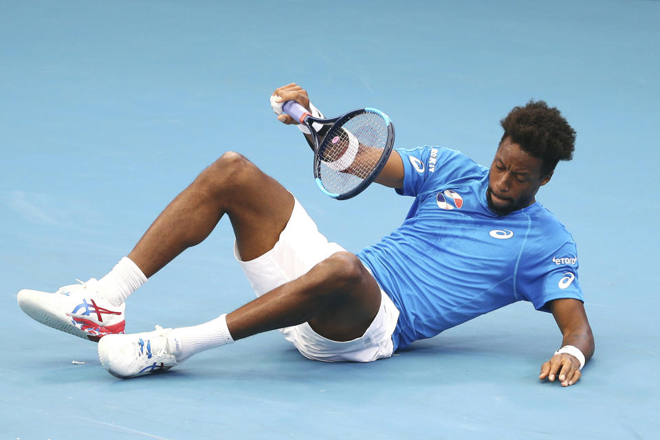 Gael Monfils of France falls to the ground after playing a shot during his match against Cristian Garin of Chile at the ATP Cup tennis tournament in Brisbane, Australia, Saturday, Jan. 4, 2020. (AP Photo/Tertius Pickard)