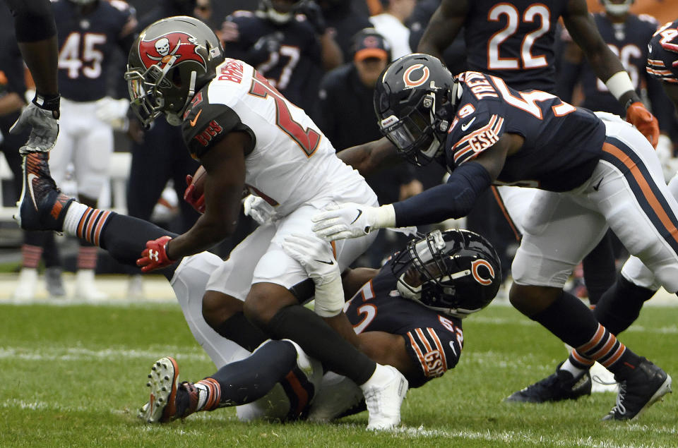 Chicago Bears linebacker Khalil Mack (52) tackles Tampa Bay Buccaneers running back Peyton Barber (25) as Chicago Bears linebacker Danny Trevathan (59) approaches them during the first half of an NFL football game Sunday, Sept. 30, 2018, in Chicago. (AP Photo/David Banks)