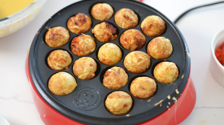 Round balls of cooked takoyaki in a takoyaki maker