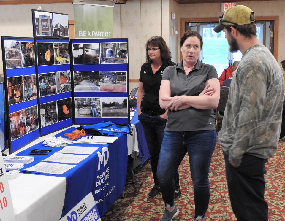 Brandy Casey of McWane Ductile speaks with a potential job seeker at a previous job fair at Coshocton Village Inn and Suites in this Tribune file photo.