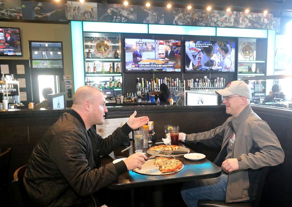 Michael Hanson, left, and Chris Higgins enjoy a lunch at On Tap Grille & Bar in Medina.