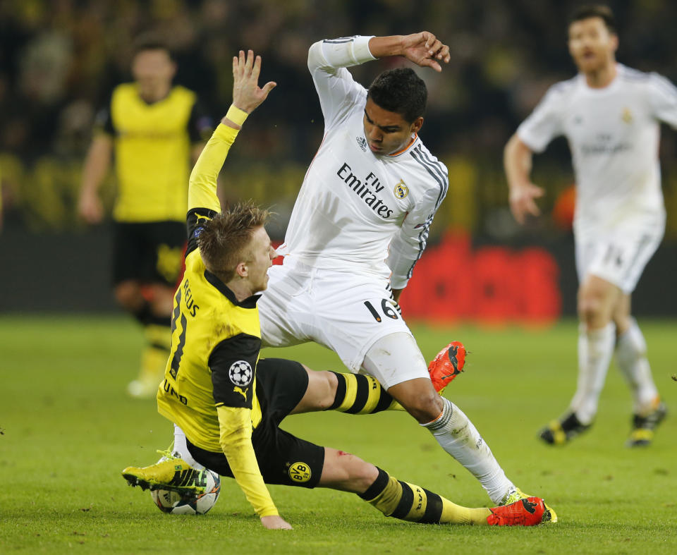 Dortmund's Marco Reus, left, and Real's Casemiro challenge for the ball during the Champions League quarterfinal second leg soccer match between Borussia Dortmund and Real Madrid in the Signal Iduna stadium in Dortmund, Germany, Tuesday, April 8, 2014. (AP Photo/Frank Augstein)