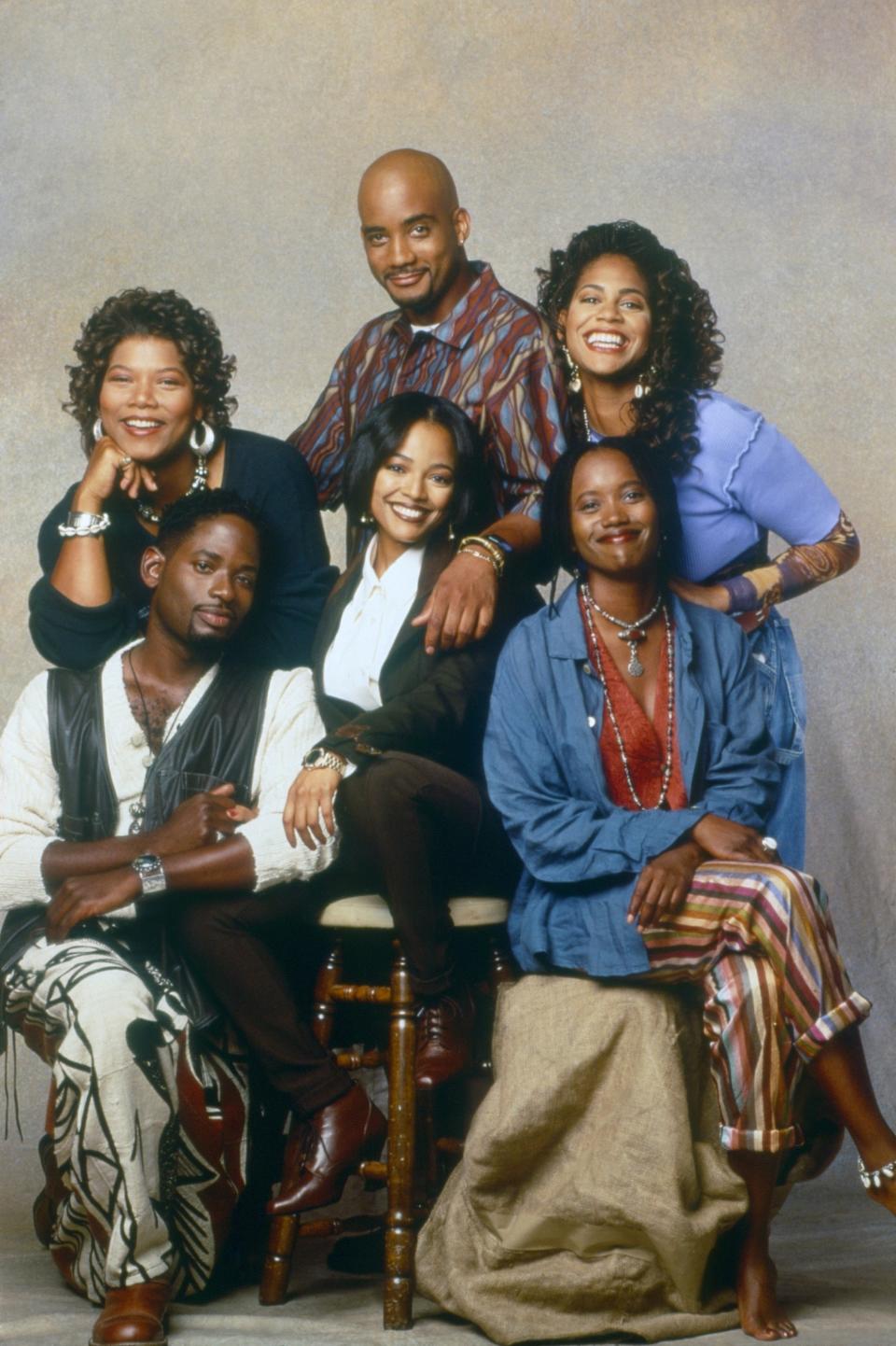 Cast of "Living Single" posing together and dressed in casual 90s fashion