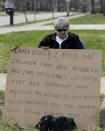 Edmond Aviv sits on a street corner holding a sign Sunday, April 13, 2014, in South Euclid, Ohio declaring he's a bully, a requirement of his sentence because he was accused of harassing a neighbor and her disabled children for the past 15 years. Municipal Court Judge Gayle Williams-Byers ordered Aviv, 62, to display the sign for five hours Sunday. It says: "I AM A BULLY! I pick on children that are disabled, and I am intolerant of those that are different from myself. My actions do not reflect an appreciation for the diverse South Euclid community that I live in." (AP Photo/Tony Dejak)