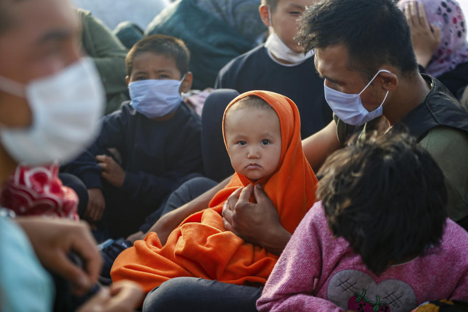 Migrants sit on a Turkish coast guard vessel after they were pulled off life rafts, during a rescue operation in the Aegean Sea, between Turkey and Greece, Saturday, Sept. 12, 2020. Turkey is accusing Greece of large-scale pushbacks at sea — summary deportations without access to asylum procedures, in violation of international law. The Turkish coast guard says it rescued over 300 migrants "pushed back by Greek elements to Turkish waters" this month alone. Greece denies the allegations and accuses Ankara of weaponizing migrants. (AP Photo/Emrah Gurel)