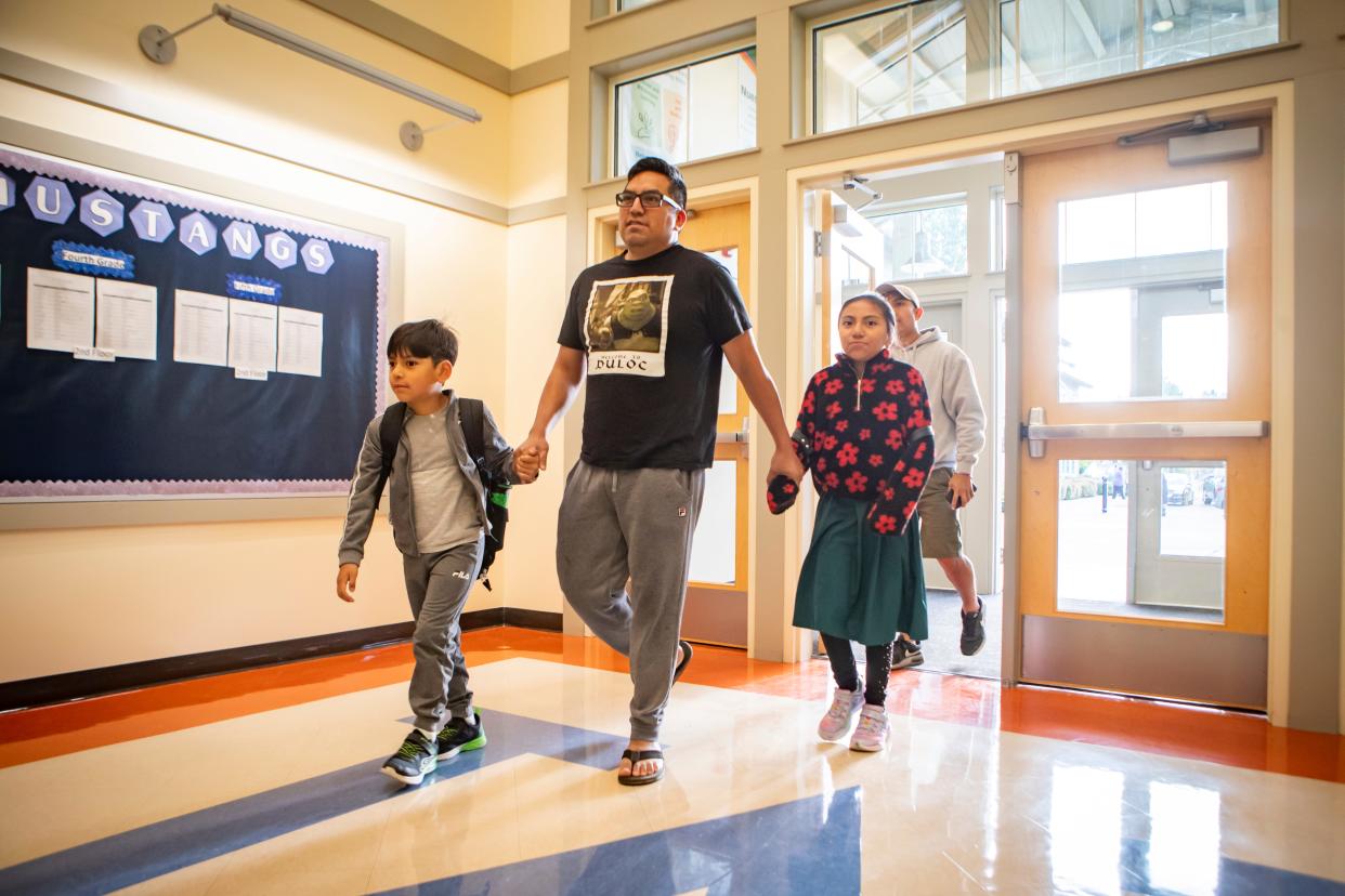 Andres Luis Contreras, center, walks Andres Luis Santiago, left, and, Cattleya Luis Santiago to class during the first day of school at Malabon Elementary School Tuesday, Sept. 3, 2024, in Eugene, Ore.