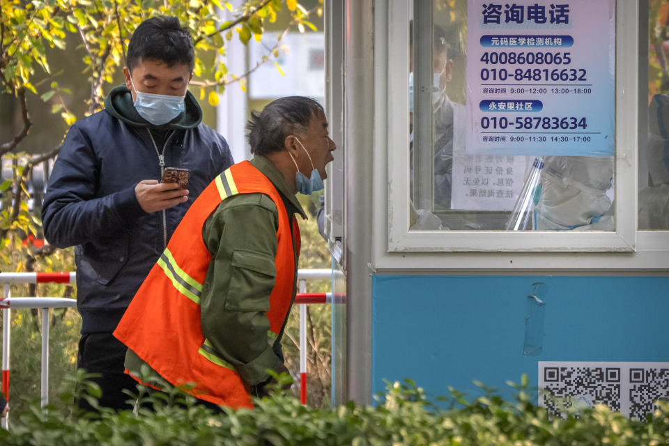 A man has his throat swabbed for a COVID-19 test at a coronavirus testing site in Beijing, Thursday, Nov. 10, 2022. A surge in COVID-19 cases has spurred lockdowns in the southern Chinese manufacturing hub of Guangzhou, adding to financial pressure that has disrupted global supply chains and sharply slowed growth in the world's second-largest economy. (AP Photo/Mark Schiefelbein)