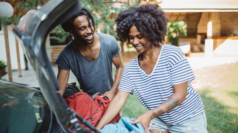 couple packing the trunk of their car