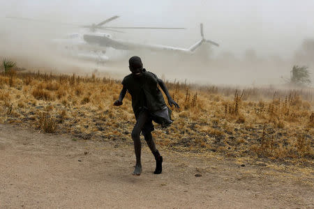 A boy moves away as a United Nations World Food Programme (WFP) helicopter lands in Rubkuai village, Unity State, northern South Sudan. REUTERS/Siegfried Modola