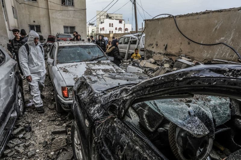 Palestinians inspect destroyed vehicles following an Israeli air attack. Abed Rahim Khatib/dpa