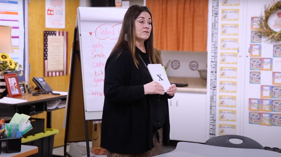 A teacher holding up a card