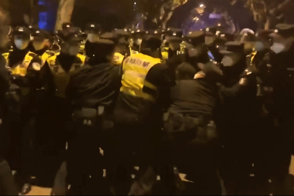 Chinese police officers surround protesters to detain them in Shanghai during the early hours of Nov. 27, 2022. What started as an unplanned vigil last weekend in Shanghai by fewer than a dozen people grew hours later into a rowdy crowd of hundreds. The protesters expressed anger over China's harsh COVID-19 policies that they believed played a role in a deadly fire on Nov. 24 in a city in the far west. (AP Photo)