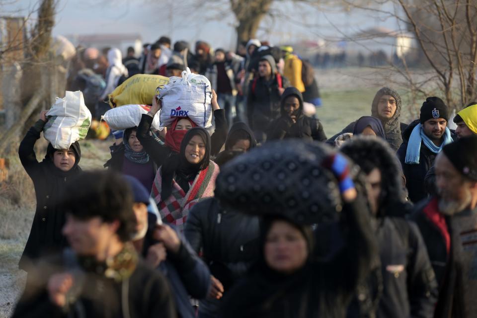 Migrants walk to reach Pazarakule border gate, Edirne, Turkey, at the Turkish-Greek border on Sunday, March 1, 2020. Turkey's President Recep Tayyip Erdogan said his country's borders with Europe were open Saturday, making good on a longstanding threat to let refugees into the continent as thousands of migrants gathered at the frontier with Greece. (AP Photo/Emre Tazegul)