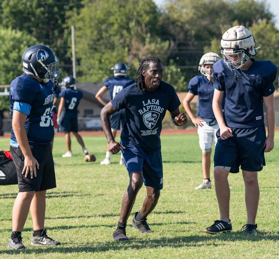 Manor New Tech football coach Derrick Lewis, going over fundamentals last year at LASA, has revitalized his new team this spring. Players said his NFL experience and positive attitude will benefit the Titans.