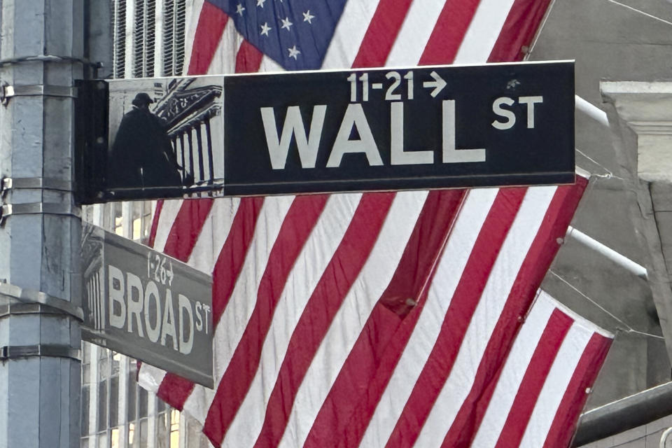 FILE - Signs at the intersection of Broad and Wall Streets stand next to flags flying at the New York Stock Exchange on Sept. 4, 2024, in New York. (AP Photo/Peter Morgan, File)