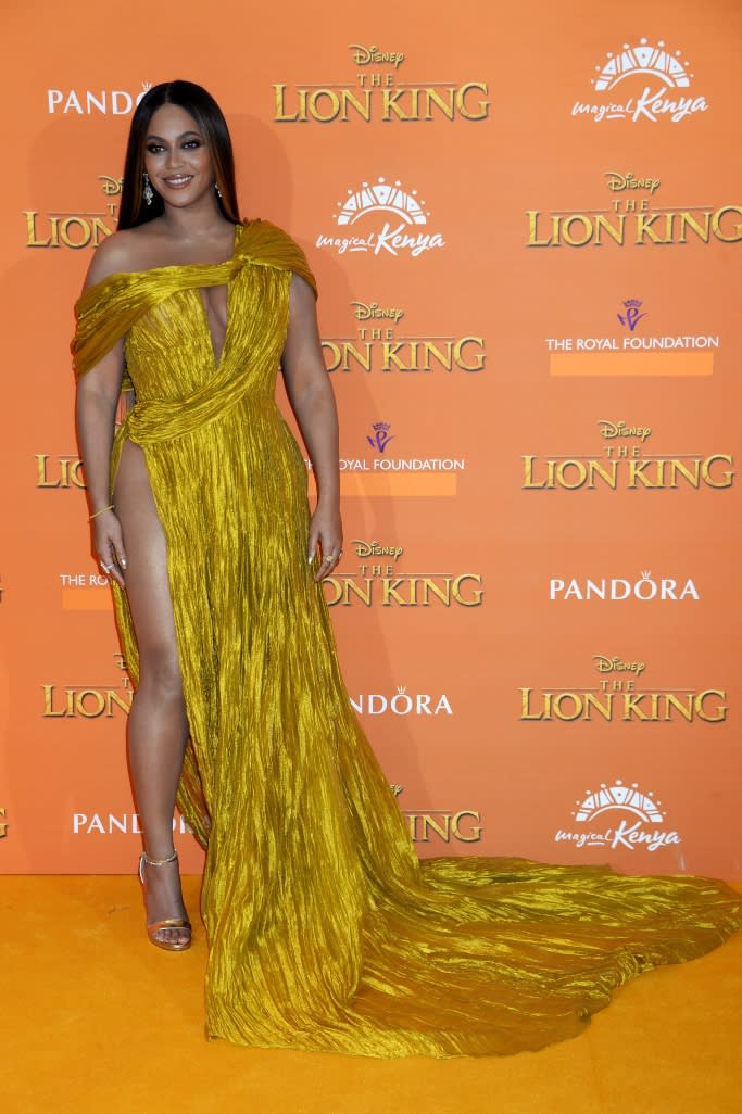 Beyonce wearing a gold off-the-shoulder dress featuring a thigh-high with gold sandals. - Credit: Shutterstock