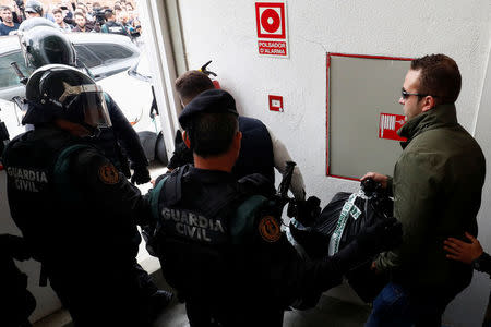 Spanish Civil Guard officers carry confiscated electoral material as they walk out from a polling station for the banned independence referendum where Catalan President Carles Puigdemont was supposed to vote in Sant Julia de Ramis. REUTERS/Juan Medina