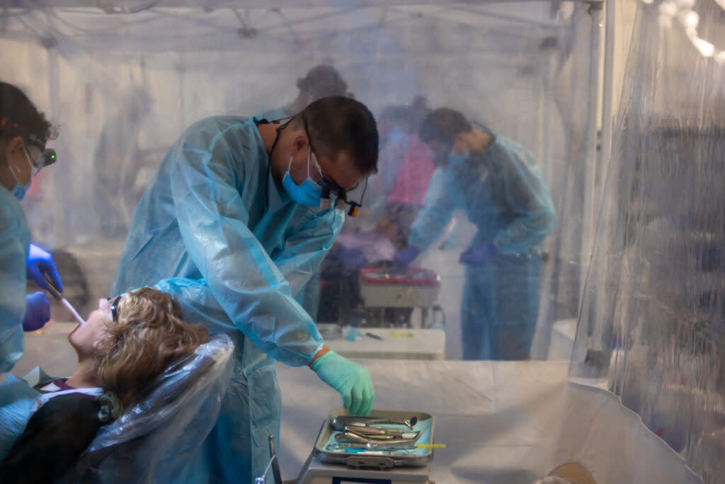 Dental students, working as volunteers, attend to patients at a Remote Area Medical mobile dental and medical clinic on October 7, 2023, in Grundy, Virginia.