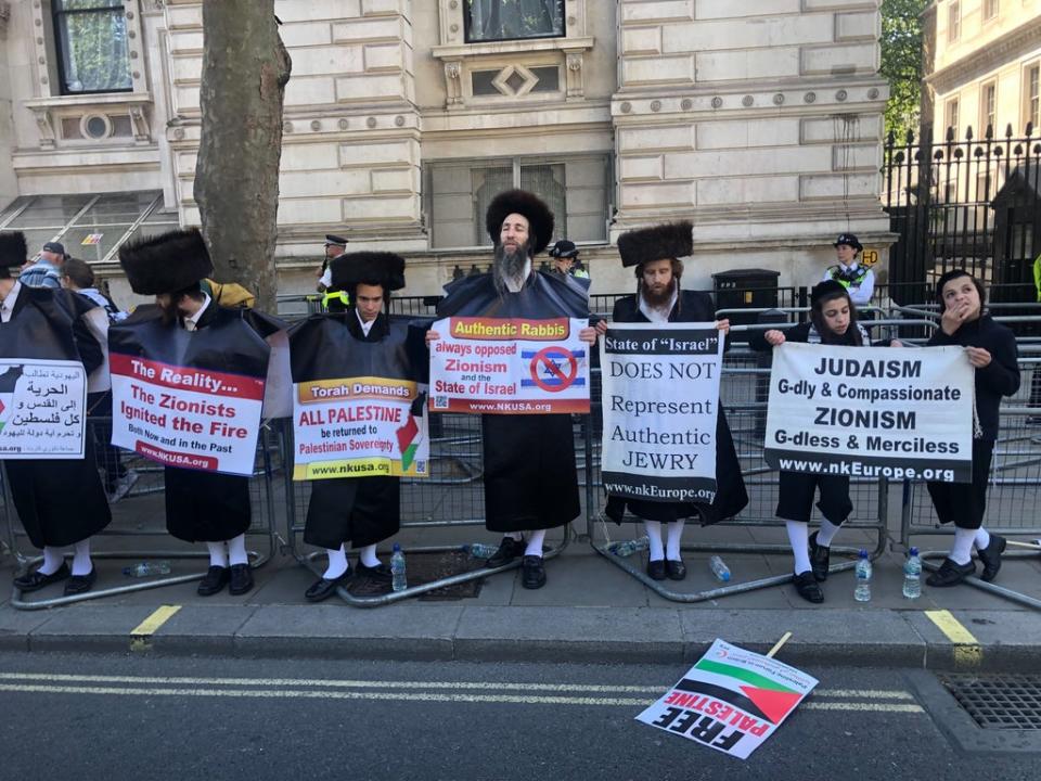 A group of protesters holding up signs at the rally in central London (Furvah Shah)