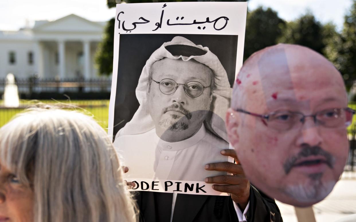 Demonstrators hold photographs of journalist Jamal Khashoggi outside the White House in Washington, DC - Bloomberg