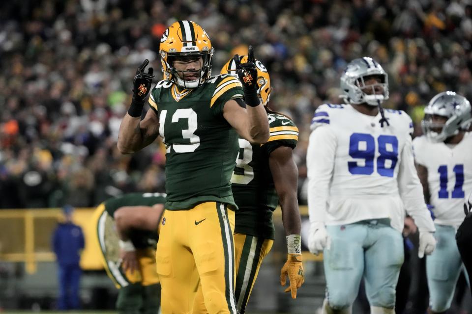 Green Bay Packers wide receiver Allen Lazard (13) celebrates a long gain after catching a pass as Dallas Cowboys' Quinton Bohanna (98) and Micah Parsons (11) stand nearby during overtime of an NFL football game Sunday, Nov. 13, 2022, in Green Bay, Wis. (AP Photo/Morry Gash)