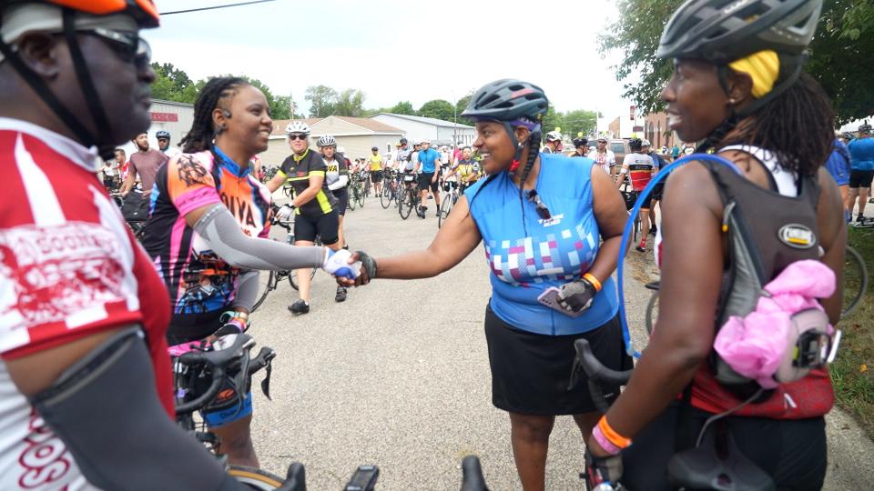 Screen capture from "Shift: The RAGBRAI Documentary": Dayna Chandler shakes hands with another bicyclist on RAGBRAI 2022.