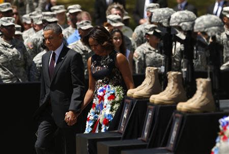 Passing a memorial to those killed, U.S. President Barack Obama and first lady Michelle Obama arrive for a memorial service in Fort Hood, Texas April 9, 2014. REUTERS/Kevin Lamarque