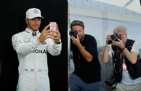 Formula One - F1 - Australian Grand Prix - Melbourne, Australia - 23/03/2017 Mercedes driver Lewis Hamilton of Britain takes a selfie during the driver portrait session at the first race of the year. REUTERS/Jason Reed