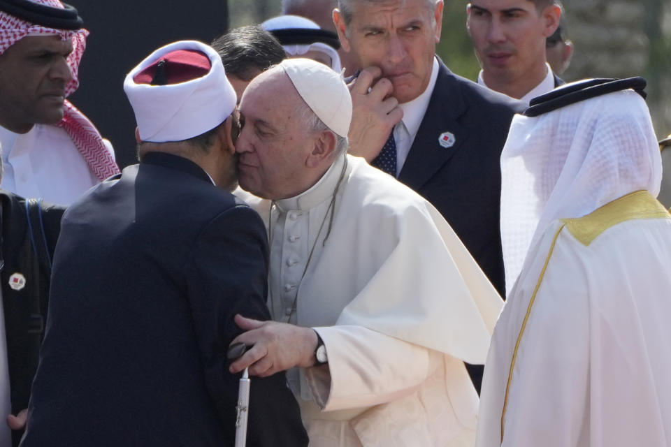 Pope Francis, center, kisses Grand Imam of al-Azhar Ahmed El-Tayeb, left, upon his arrival to attend the closing session of the "Bahrain Forum for Dialogue: East and west for Human Coexistence", at the Al-Fida square at the Sakhir Royal palace, Bahrain, Friday, Nov. 4, 2022. Pope Francis is making the November 3-6 visit to participate in a government-sponsored conference on East-West dialogue and to minister to Bahrain's tiny Catholic community, part of his effort to pursue dialogue with the Muslim world. (AP Photo/Hussein Malla)