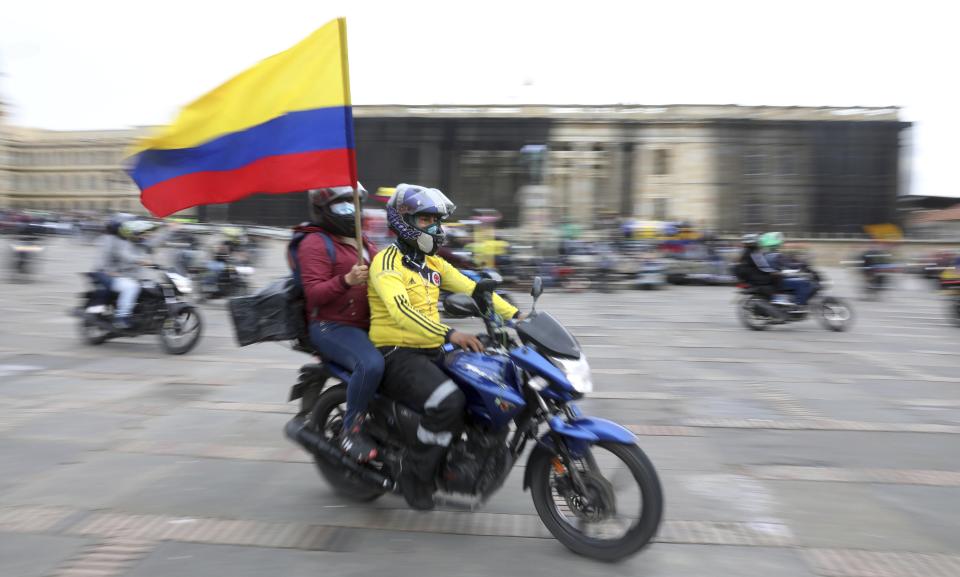 Hombres en motocicletas celebran el domingo 2 de mayo de 2021 en la Plaza Bolívar después de que el presidente Iván Duque retirara una impopular reforma tributaria presentada en el Congreso, la cual generó protestas callejeras, en Bogotá, Colombia. (AP Foto/Fernando Vergara)