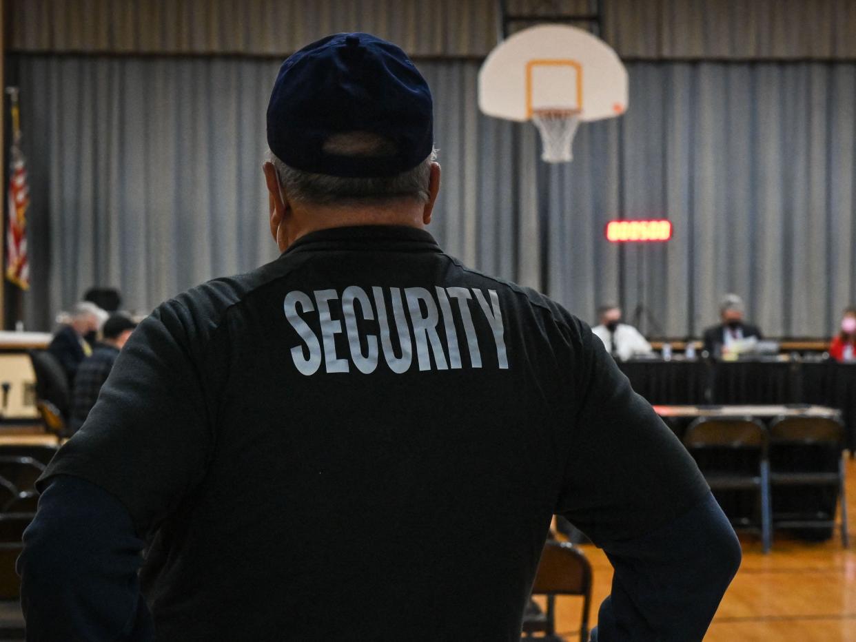 back of security guard whose shirt reads "security"