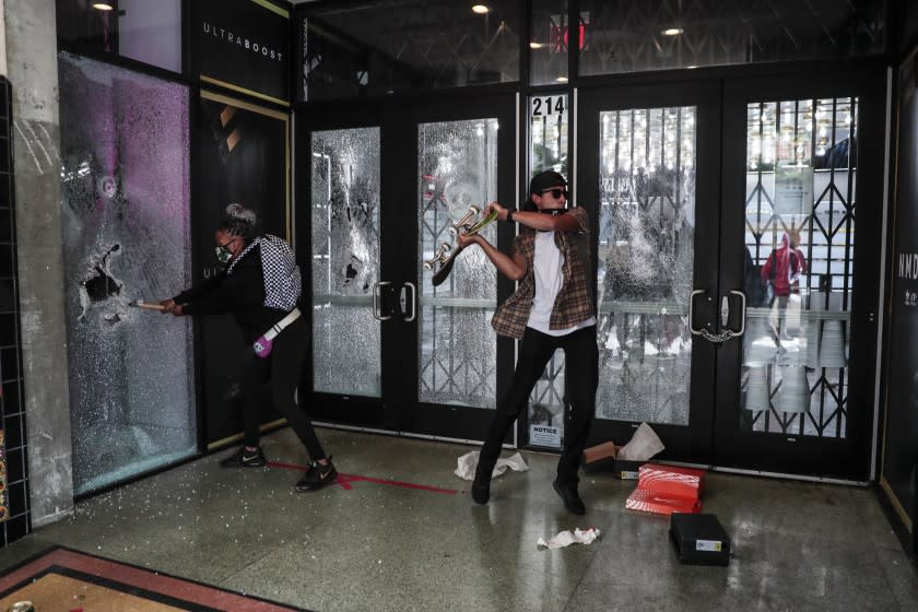 Santa Monica, CA, Sunday May 31, 2020 - One vandal uses a skateboard as another, a hammer at ShoePalace as unrest continues in the wake of the death of George Floyd in Minneapolis. (Robert Gauthier / Los Angeles Times)