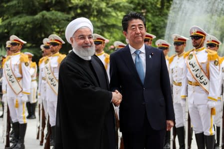 Iranian President Hassan Rouhani shakes hands with Japan's Prime Minister Shinzo Abe, during a welcome ceremony in Tehran