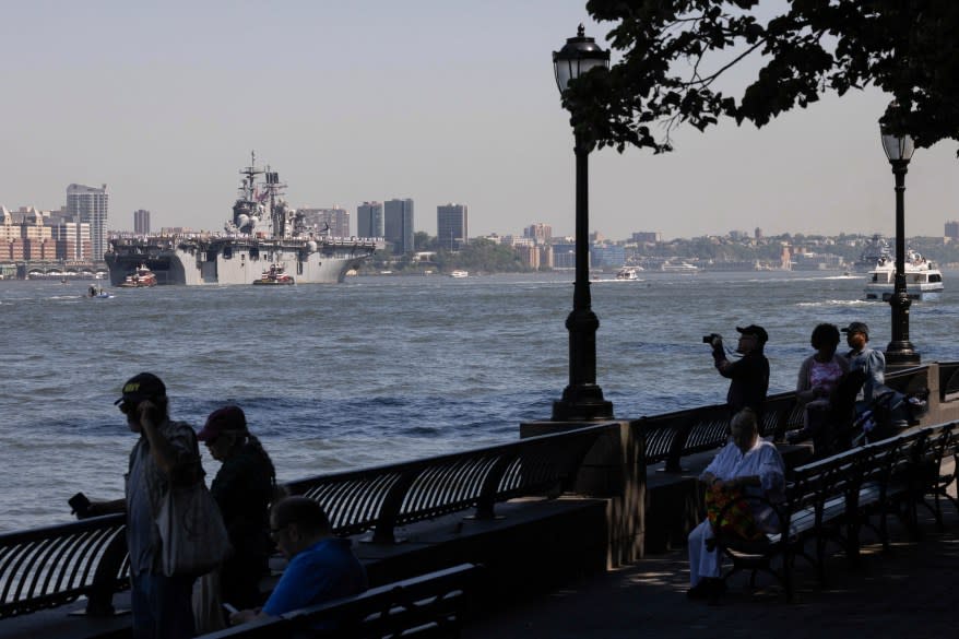 People watch the USS Bataan pass the Statue of Liberty.