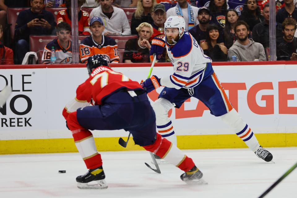 Jun 8, 2024; Sunrise, Florida, USA; Edmonton Oilers forward Leon Draisaitl (29) passes the puck against Florida Panthers defenseman Niko Mikkola (77) in game one of the 2024 Stanley Cup Final at Amerant Bank Arena. Mandatory Credit: Sam Navarro-USA TODAY Sports